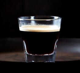 Coffee in glass cup on dark background. Close up. Copy space