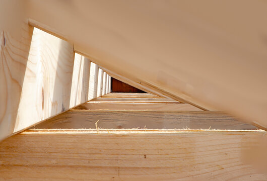 wooden roof construction with background of depth of field and shadow as background and symbol of roof construction