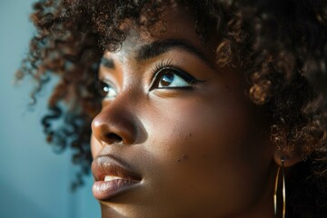 Closeup of a young woman with beautiful curly hair and striking eyeliner in natural light