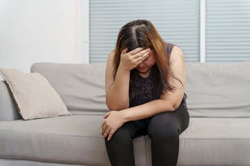 Sad Overweight plus size woman thinking about problems on sofa upset girl feeling lonely and sad from bad relationship or Depressed woman disorder mental health