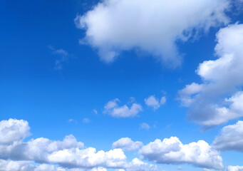 Clear blue sky texture and white fluffy cloud nature background. The sun shines bright in the...