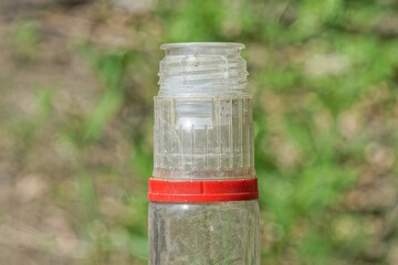 part one of white open glass bottle  on a green background