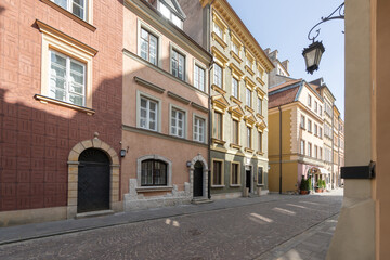 A vibrant historic street in the old town, featuring colorful buildings with arched doorways and...