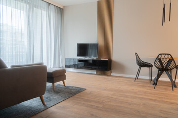 A contemporary living and dining area featuring modern furniture, including a sleek TV stand,...
