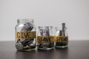 Give, Save, Spend money jars. She organized her finances into three jars labeled Give, Save and Spend, ensuring a balanced approach to managing her money. words, lettering, donate, jar, money.
