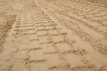 Sand tyre mark background. Tire tracks and footprints on beach sand. Machine Imprints.