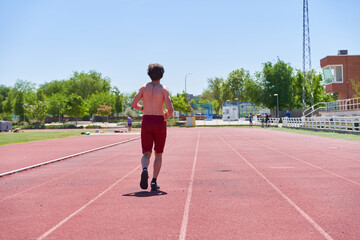 Fototapeta premium man training on a running track. general view of a shirtless man running.