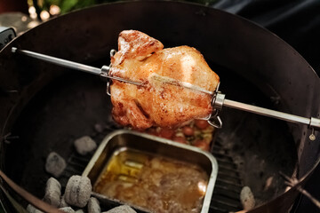 Grillhähnchen, Grillhendl am Drehspieß im Kugelgrill