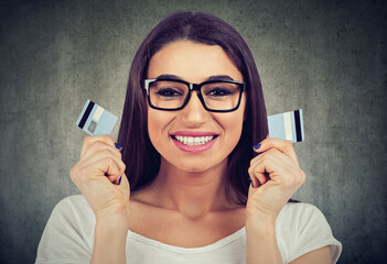 Happy debt free woman in glasses holding a credit card cut in two pieces