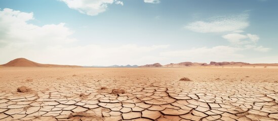 Dry desert landscape with cracked earth, ideal for background use in design projects with copy space image.