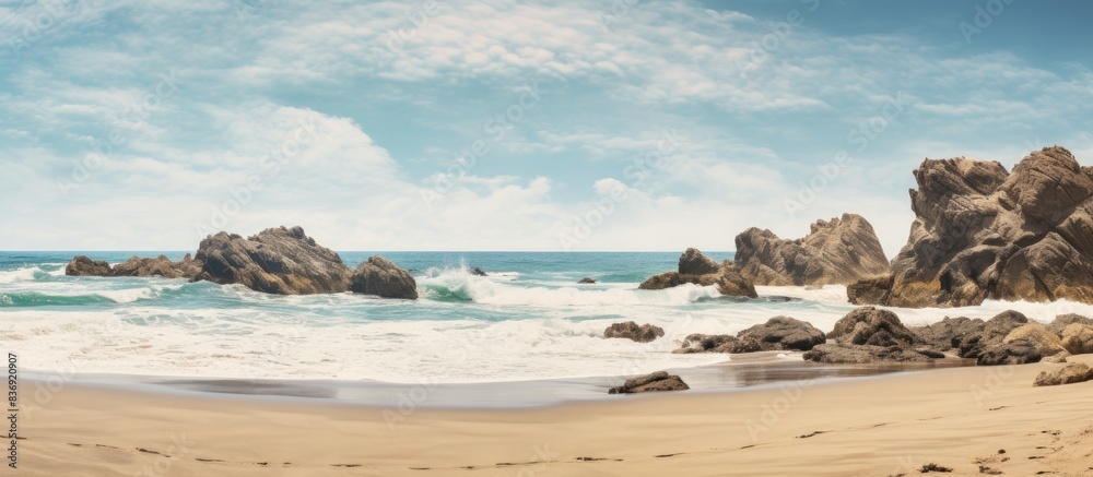 Aufkleber sandy beach with rocks and waves, suitable for a copy space image.