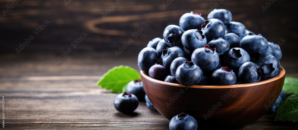 Poster Close up image of fresh blueberries in a small bowl on a wooden table with copy space image.