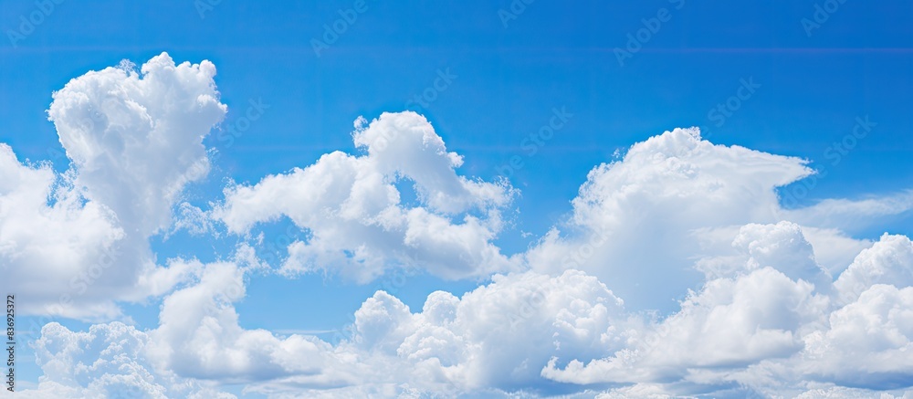 Poster background of blue sky with fluffy white clouds providing copy space image.