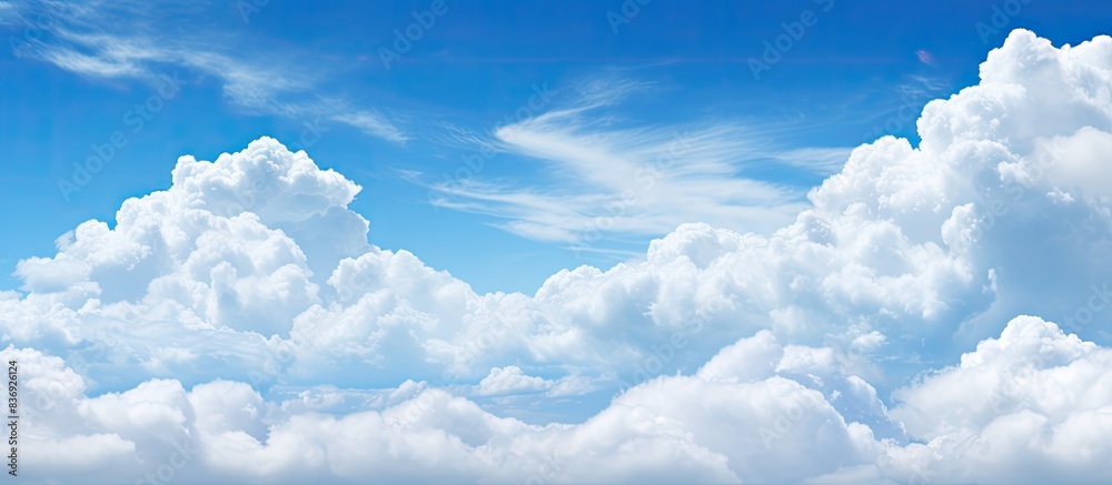 Poster Scenic view of a clear blue sky complemented by fluffy white clouds in a copy space image.