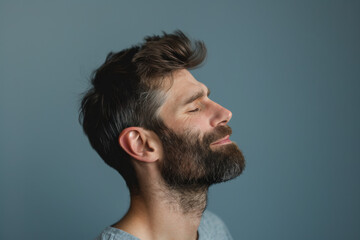 Obraz premium A close up of a man with beard and closed eyes looking to a side