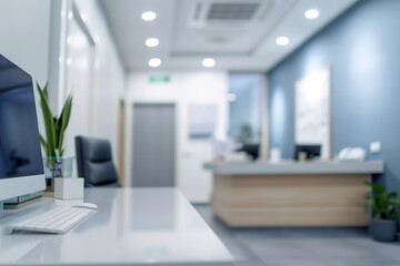 Fototapeta premium Blurred view of a contemporary medical clinic interior with a reception desk, office supplies, plants and a computer. Shallow depth of field
