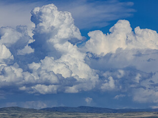 picturesque thick cumulus clouds close up on a bright blue summer sky