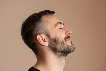 Obraz premium A close up of a man with beard and closed eyes looking to a side