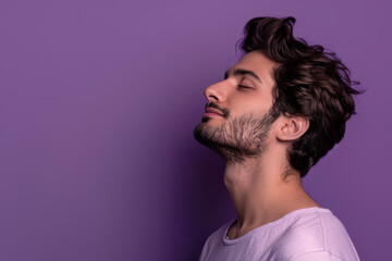 A close up of a man with beard and closed eyes looking to a side