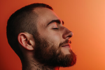 Obraz premium A close up of a man with beard and closed eyes looking to a side