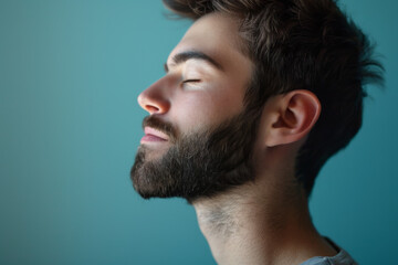 Obraz premium A close up of a man with beard and closed eyes looking to a side