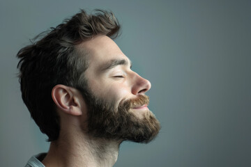 Obraz premium A close up of a man with beard and closed eyes looking to a side