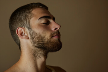 Obraz premium A close up of a man with beard and closed eyes looking to a side