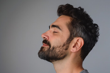 Obraz premium A close up of a man with beard and closed eyes looking to a side