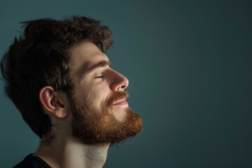 Fototapeta premium A close up of a man with beard and closed eyes looking to a side