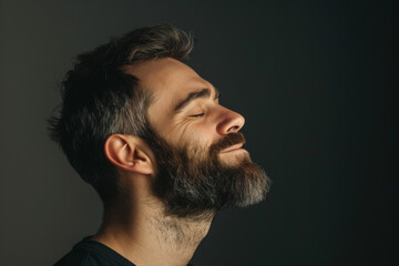 Fototapeta premium A close up of a man with beard and closed eyes looking to a side