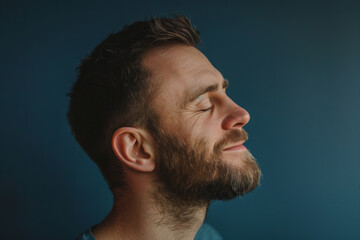 Fototapeta premium A close up of a man with beard and closed eyes looking to a side