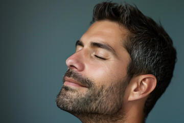 Obraz premium A close up of a man with beard and closed eyes looking to a side