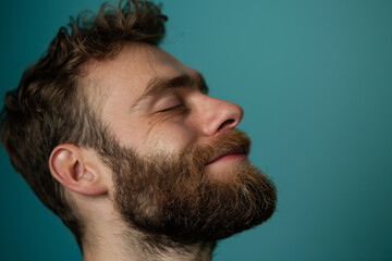 Obraz premium A close up of a man with beard and closed eyes looking to a side