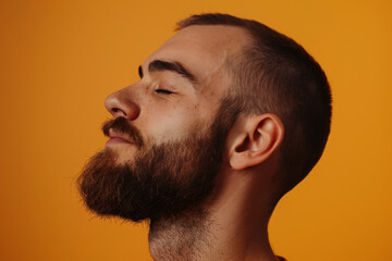 Obraz premium A close up of a man with beard and closed eyes looking to a side