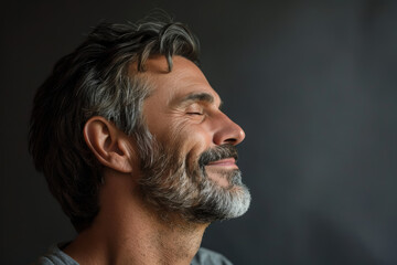 Fototapeta premium A close up of a man with beard and closed eyes looking to a side
