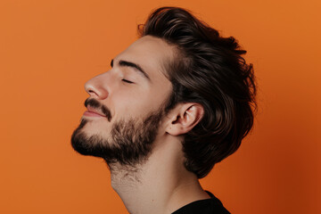 Fototapeta premium A close up of a man with beard and closed eyes looking to a side