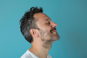 Obraz premium A close up of a man with beard and closed eyes looking to a side