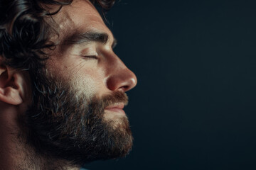Fototapeta premium A close up of a man with beard and closed eyes looking to a side