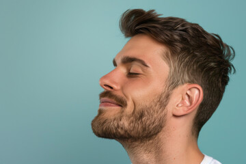 Obraz premium A close up of a man with beard and closed eyes looking to a side