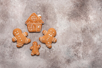 Gingerbread man and house on a brown background. Top view, flat lay.