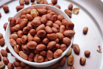 groundnuts in white bowl isolated on white background, salted roasted nuts