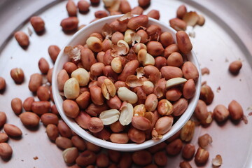 groundnuts in white bowl isolated on white background, salted roasted nuts