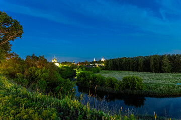 Fototapeta premium Suzdal, Vladimir region, Russia, Golden Ring - View from the observation deck of the bend of the river and the Church of the Entrance of the Lord to Jerusalem, the Assumption Church and the colonnade 
