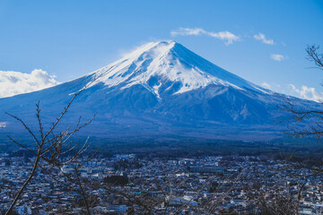 A distant view on Mt Fuji in Japan on a clear,The top parts of the volcano are covered with a layer...