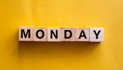 Obraz premium Wooden blocks with text MONDAY. Business banner. Start of the week. Yellow backdrop. Flat lay.
