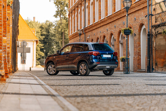 Photo of a blue Suzuki Vitara. They show details of the car from the outside. In an industrial site. The photo is suitable for use in marketing materials, advertisements or press articles.