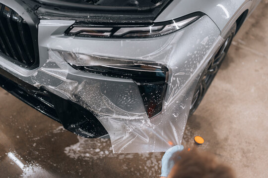 Photo of BMW X7 G07. The photo shows the application of ppf foil. Complementary work in the detailing studio with wrapping