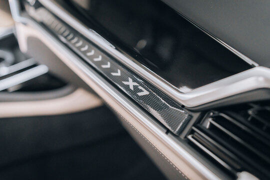Photo of a grey BMW X7 G07. They show details of the car from the outside. Rims, emblems, headlights, lamps and interior, dashboard. The photo is suitable for use in marketing materials, advertisement