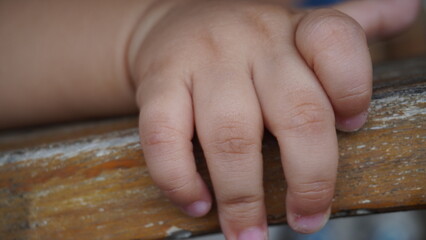 A close-up shot of a small, cute child's hand. The image captures the delicate and adorable features of the child's hand, highlighting its innocence and charm. This photo emphasizes the beauty and ten