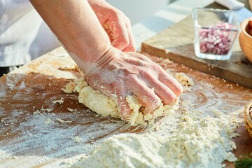 Step-by-step cooking process. Kneading the dough with the cook's hands.